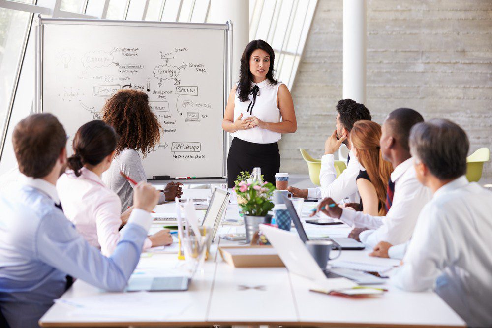 Woman speaks in front of her team